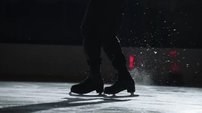 男花样滑冰运动员正在溜冰场上执行步骤顺序，脚踩溜冰鞋的特写镜头，运动型男子正在训练