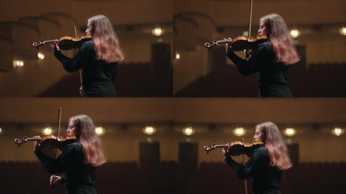 女小提琴手在音乐厅演奏小提琴，爱乐音乐厅的音乐家肖像
