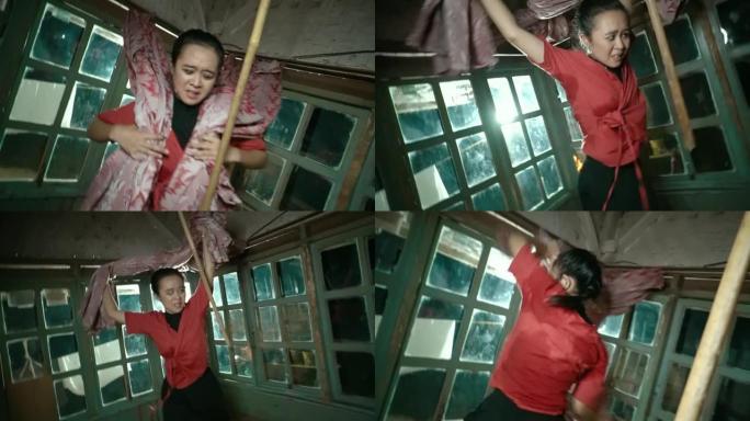 亚洲盲人妇女在愤怒中与红色窗帘共舞