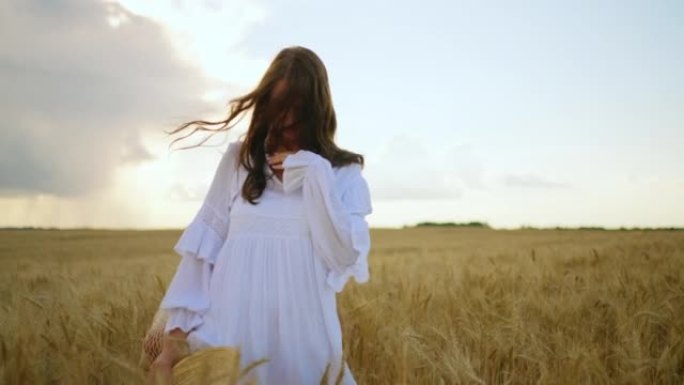 穿着白色连衣裙的黑发女人在夏天的金色黑麦田野上旋转，幸福无忧无虑