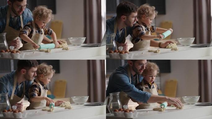 可爱的小孩，有着有趣的卷发，正在厨房玩耍，生面团，父亲，父亲和儿子的大师班