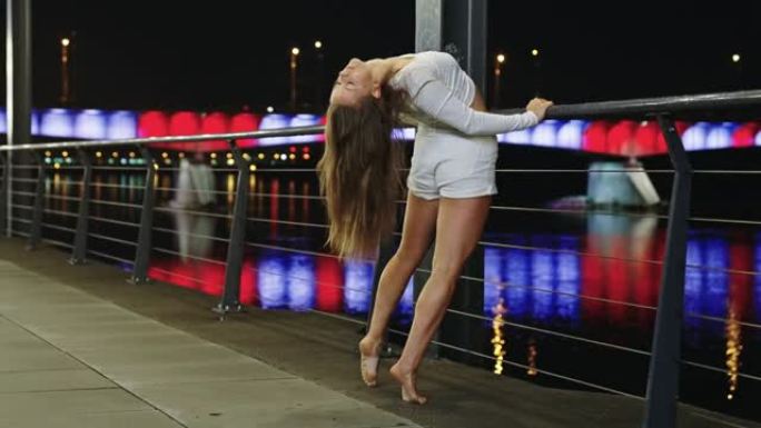 年轻女子在潮湿的城市街道上表演自由式舞蹈。