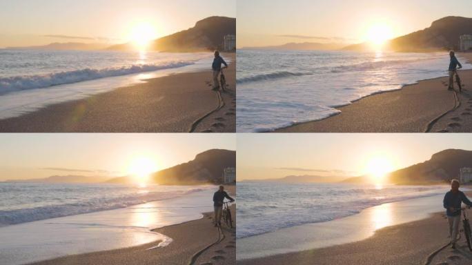 成熟的男人沿着空旷的海滩推自行车