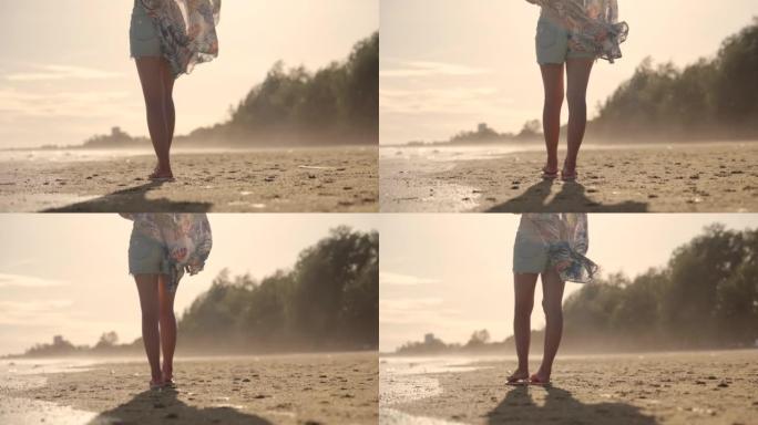 使用智能手机的亚洲妇女在日落时在海滩上自拍。