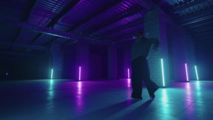 一名钢铁女子在带有紫色蓝色霓虹灯的大厅中以现代风格跳舞嘻哈自由泳。女性职业嘻哈舞者