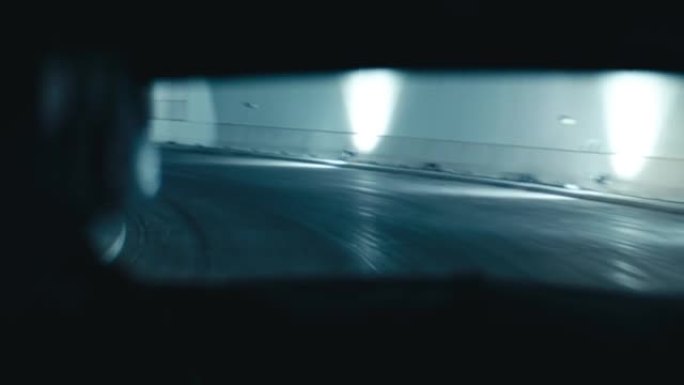 后座乘客POV跑车在夜间通过隧道行驶，驾驶员轮廓。强蓝光