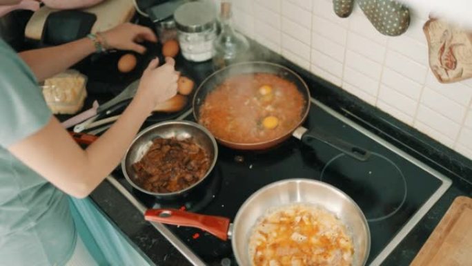 女人煮鸡蛋配西红柿和青椒 (menemen) 作为早餐