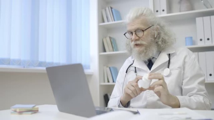 全科医生展示药瓶，通过视频通话与患者交谈