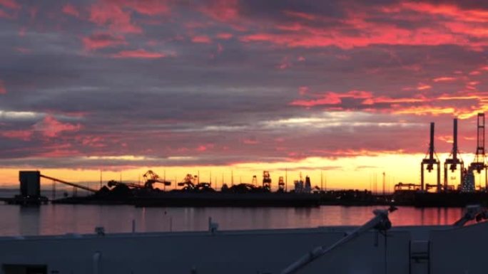 商业装船设施的日落视图，前景中的渡轮