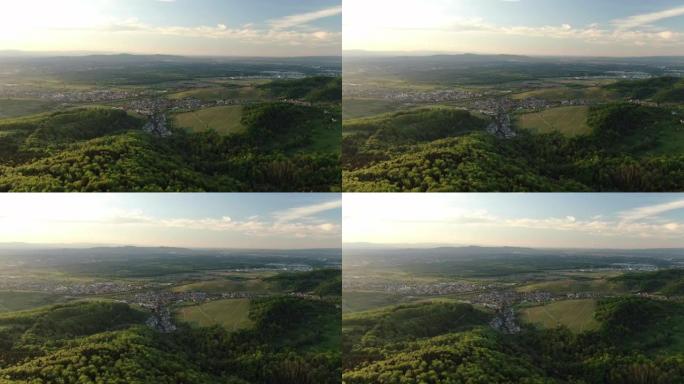 空中无人机拍摄日落时丘陵起伏的乡村小镇
