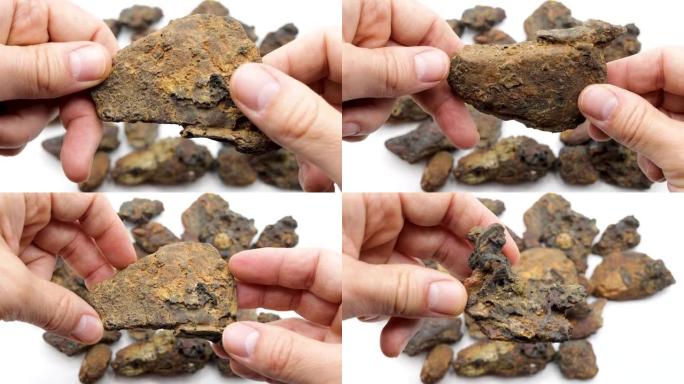 向相机展示一种称为赤铁矿，褐铁矿或磁铁矿的岩石，该岩石被工业界用来获取铁