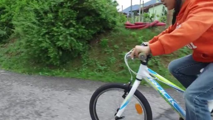 在一个乡村小镇上骑自行车的小男孩的镜头之后