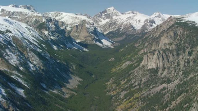 黄石国家公园附近的白雪皑皑的山峰，陡峭的悬崖和茂密的森林