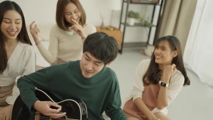 年轻人和他的朋友在家里弹吉他