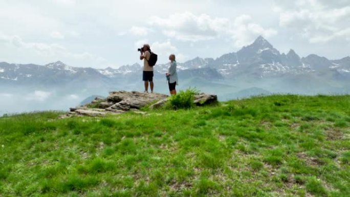 徒步旅行夫妇到达山顶并欣赏山景的鸟瞰图