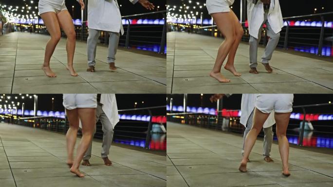 年轻多样的夫妇在潮湿的城市街道上表演现代快速舞蹈。玩得开心。腿部特写