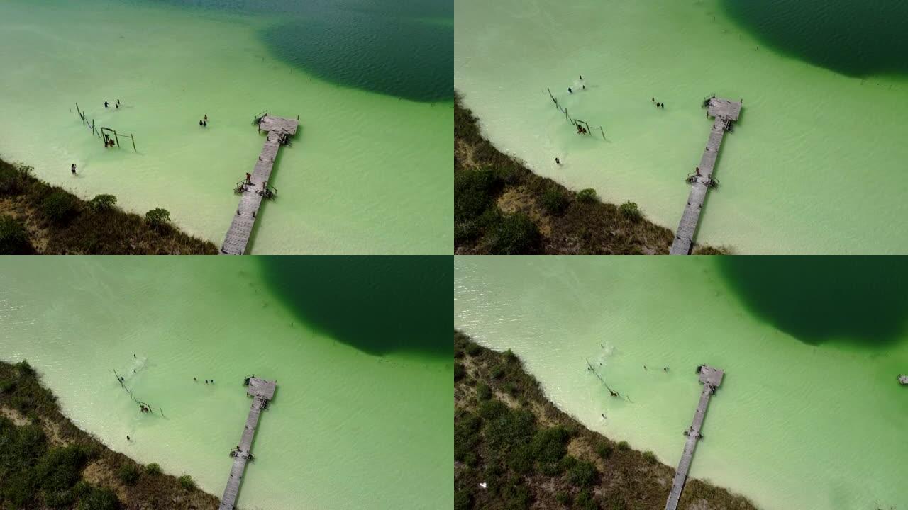 空中无人机拍摄了一个浅湖，周围是两个码头和绿水的植被