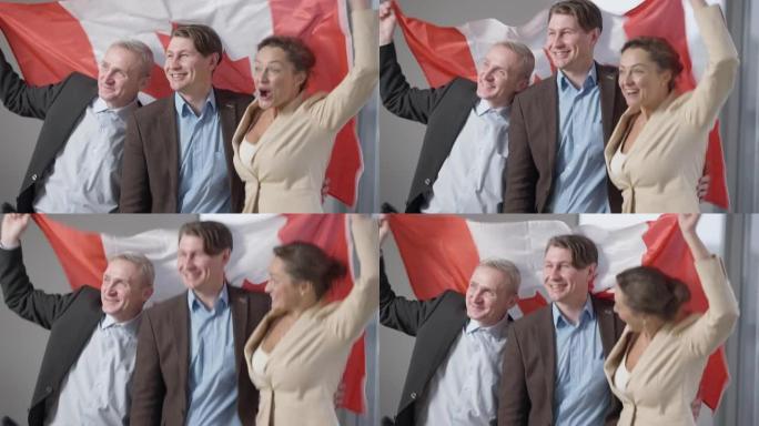 快乐的男人和女人在室内跳着加拿大国旗。快乐兴奋的高加索上班族为成功而自豪。合作和团队合作的结果。