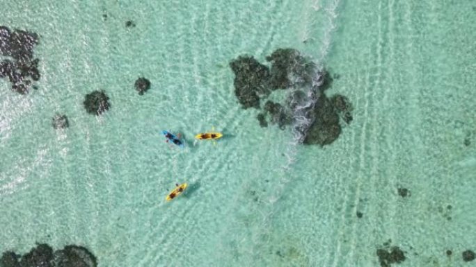 游客在海洋的珊瑚礁上皮划艇的高空拍摄，皮划艇在水晶般清澈的大海上