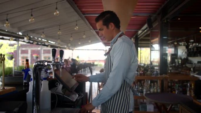 在一家餐厅工作的拉丁美洲服务员通过坚固的屏幕设备在系统中下订单