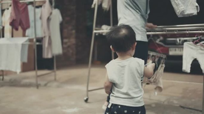 小男孩帮妈妈挂洗过的衣服