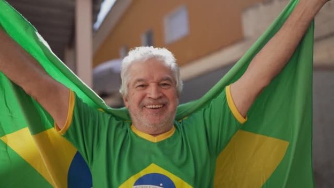 在家中用巴西国旗庆祝的高级男子肖像