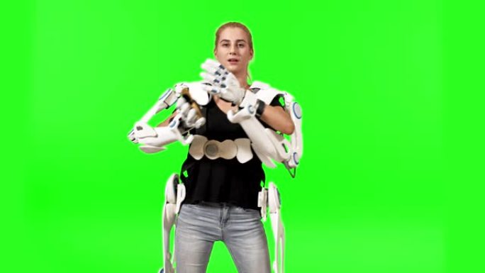 未来就是现在。戴着外骨骼的女人被隔离在绿色屏幕上。携带重型库存