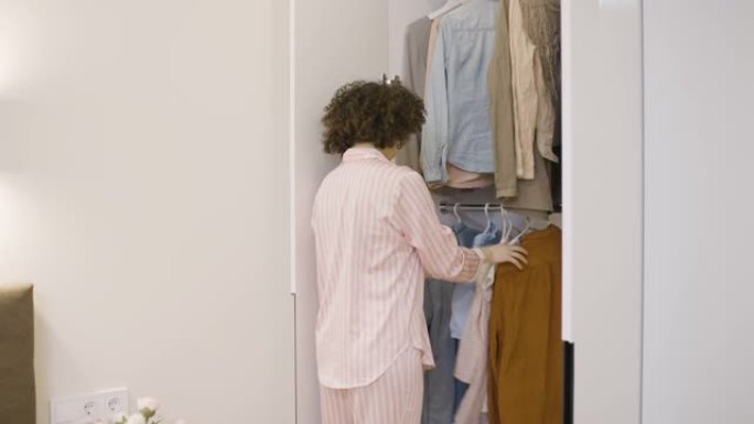 烦恼的女人选择在衣柜里穿什么，不喜欢任何东西