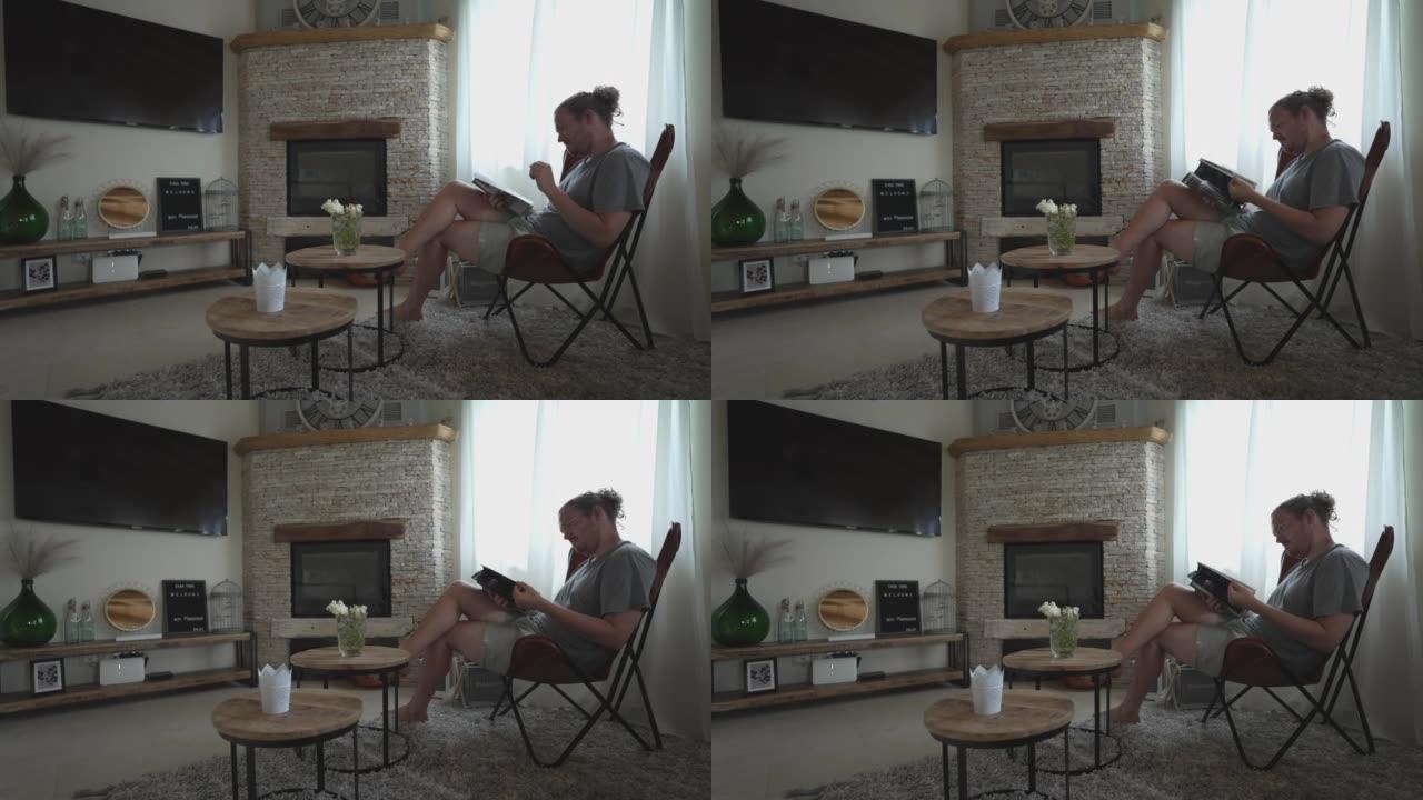 男人坐在客厅的椅子上看书