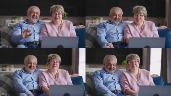 快乐的祖父和祖母正在通过与朋友或孩子的在线视频聊天进行交流，退休人员正在向笔记本电脑的网络摄像头挥手