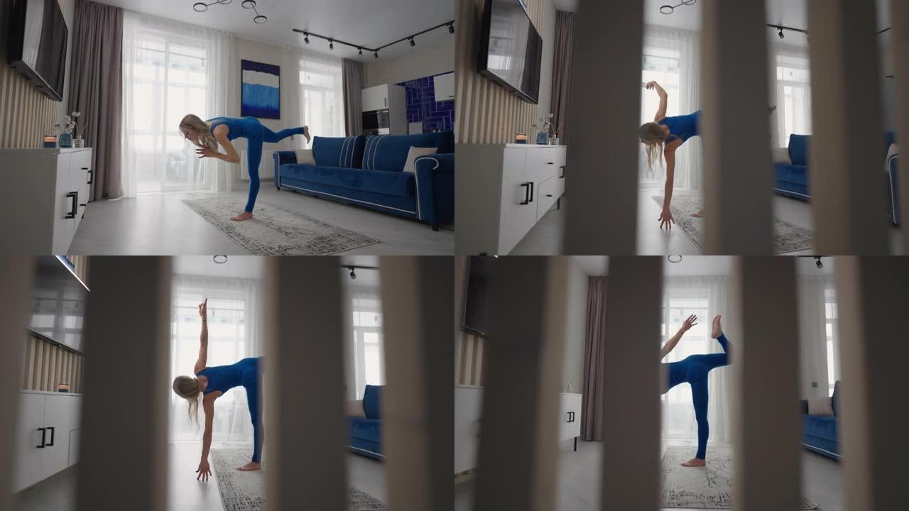 年轻女子坐在地毯上冥想，做伸展运动，做瑜伽，早上在家的蓝色运动服灯光室。女人在家练习瑜伽