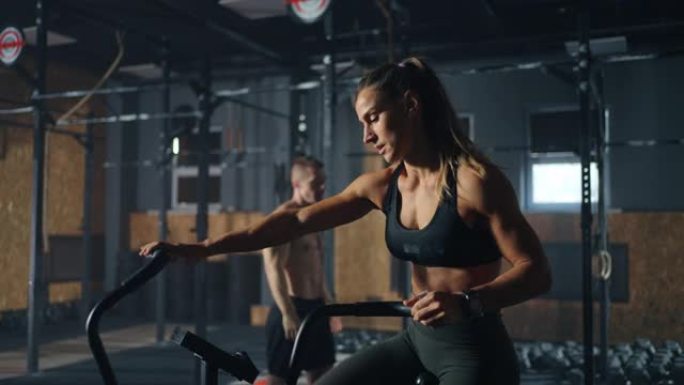 运动女子正在健身房训练带手柄的固定自行车，肖像射击，慢动作