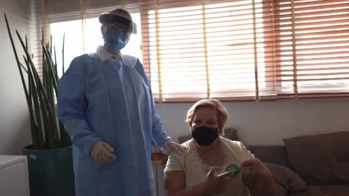 在家中的医生和病人的肖像，使用 “fui vaginado' (已接种疫苗)” 的戴口罩的高级妇女