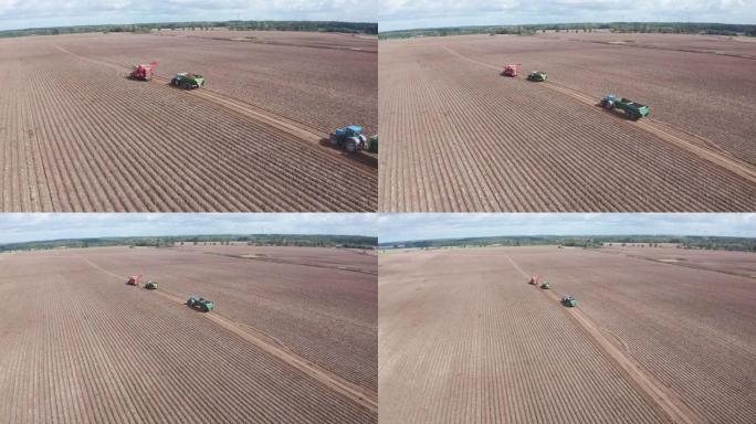 农业机械在耕田上移动。在远处收获土豆。无人机的观点