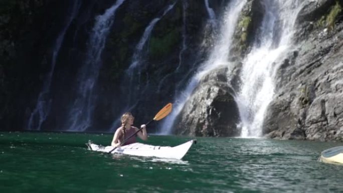 瀑布附近的女性皮划艇运动员的独奏