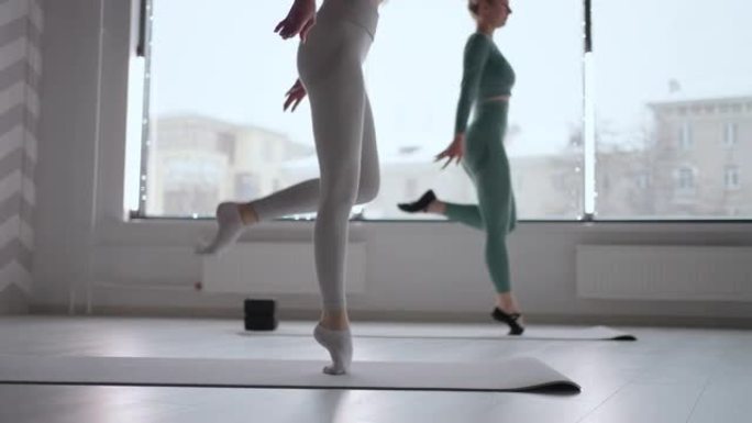 一位女芭蕾舞演员在没有足尖鞋的情况下穿着袜子行走的特写镜头。慢动作训练女芭蕾舞演员的脚