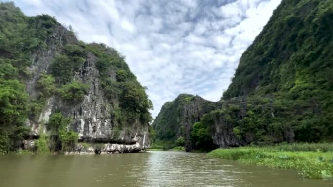 越南北部宁平省的Tam Coc洞穴和湖泊的美丽船景，在炎热的夏日里，有令人惊叹的山脉、岩石和稻田。