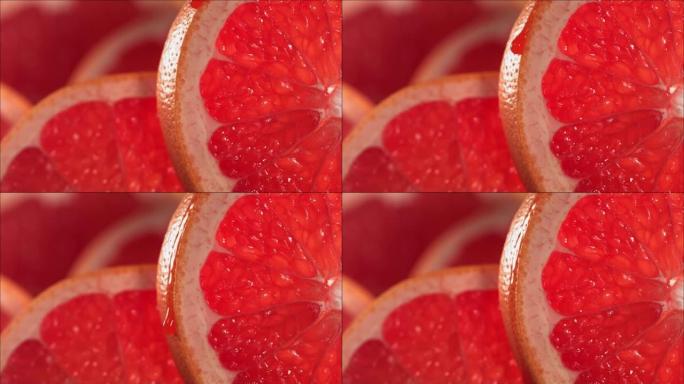 一滴葡萄柚汁从成熟多汁的葡萄柚片的表面流下。慢动作4K