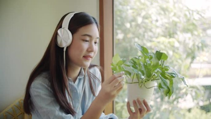 微笑的亚洲女人拿着一棵小植物