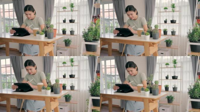 亚洲女性在客厅里玩平板电脑，架子上装饰着植物。