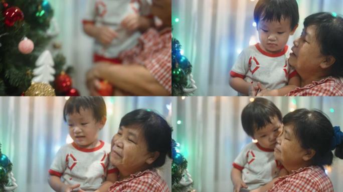 小男孩第一次和妈妈一起装饰圣诞树。
