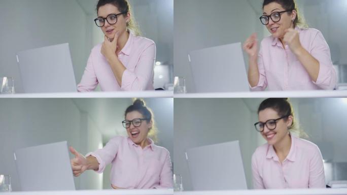 非常高兴的激动的女人在眼镜上看着笔记本电脑显示屏，竖起大拇指，欣喜的好消息，领取绿卡或签证，领取学费