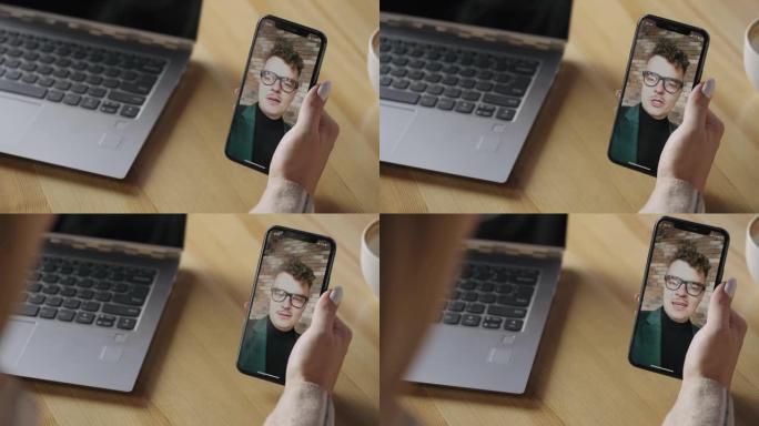 女人正在与男友通过视频会议打电话，在屏幕上与男人一起拍摄智能手机的特写镜头