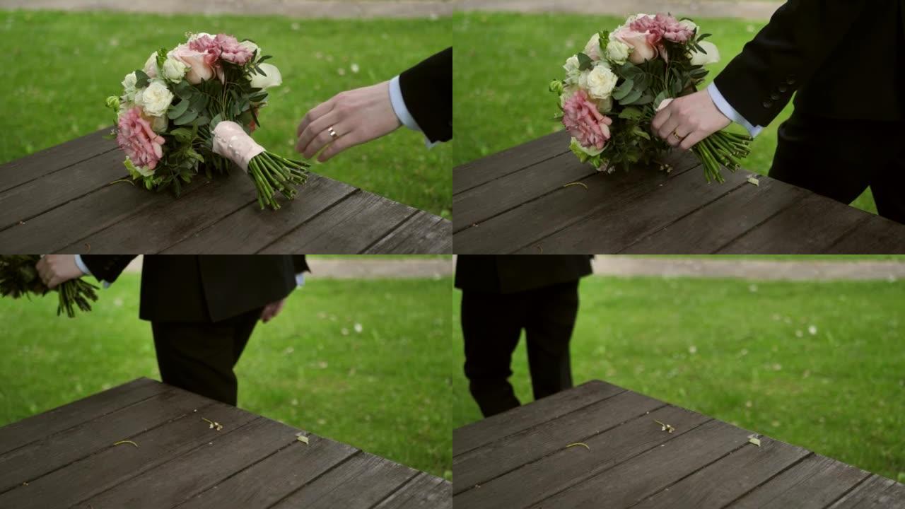 新郎在仪式前拿着婚礼花束。新娘的花束