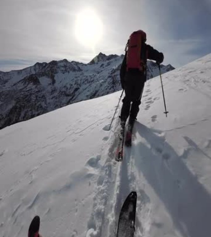 第一人称视角在阳光明媚的日子里在偏远的高山滑雪登山
