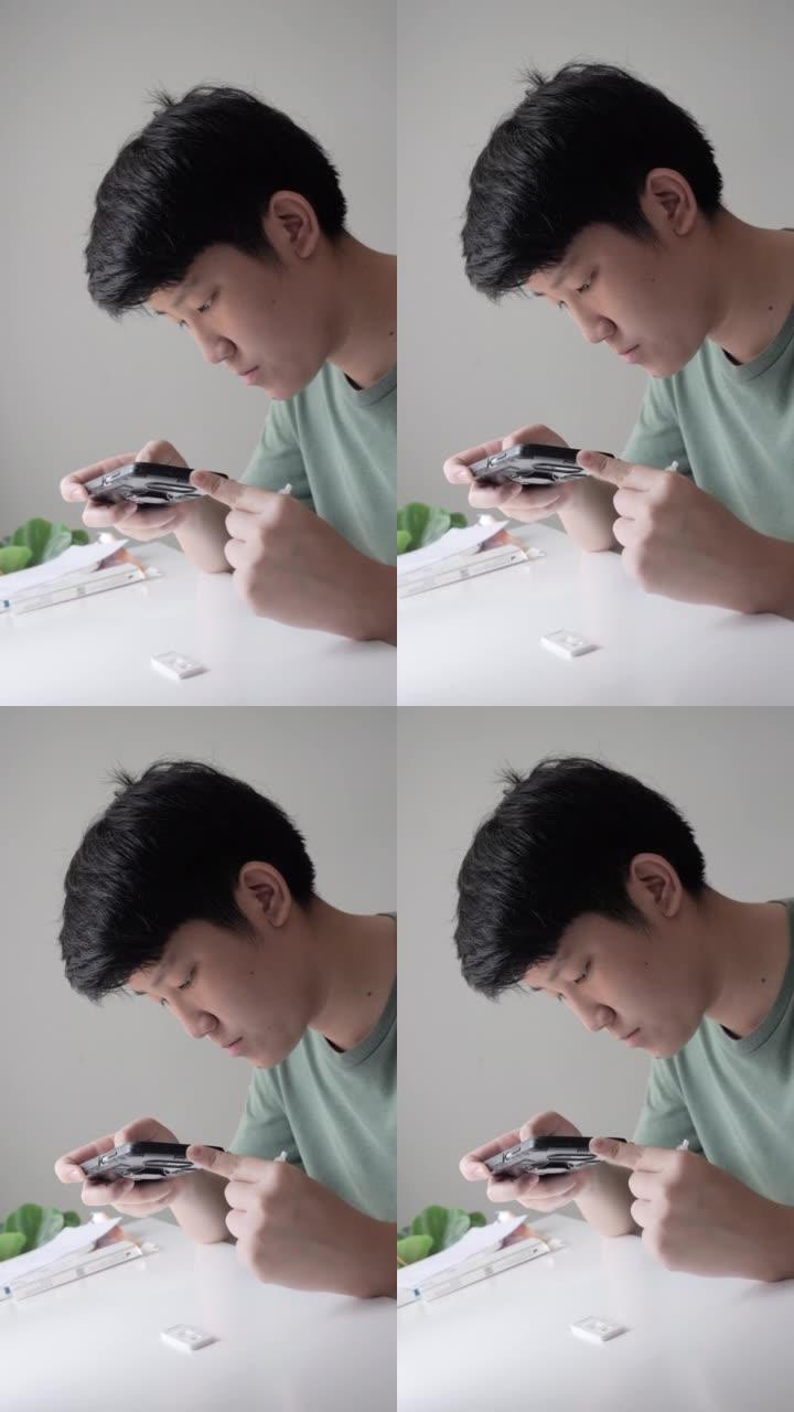 亚洲男孩通过智能手机制作视频，用于在家中使用新型冠状病毒肺炎进行快速测试，然后在在线教室发送给他的老