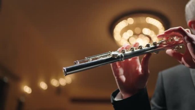 爱乐音乐厅的铜管乐团，长笛演奏家正在演奏长笛，管乐器的特写镜头