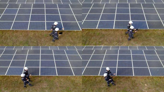 太阳能电池板发电站，电气工程师检查建筑物外的太阳能电池农场。