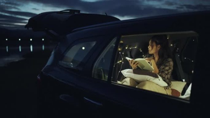 女人晚上坐在车里看书