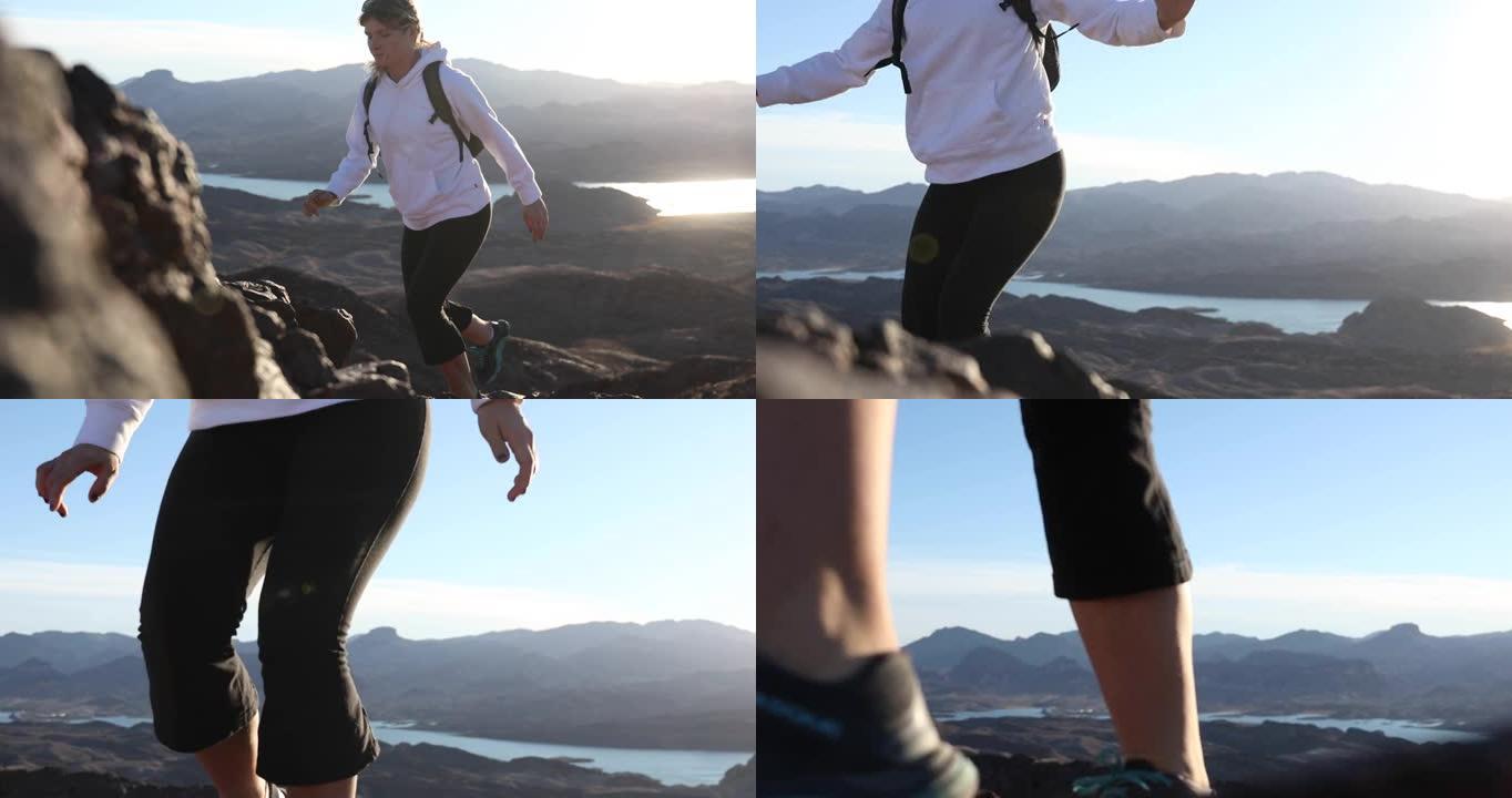 女性徒步旅行者在沙漠上攀登岩石山脊